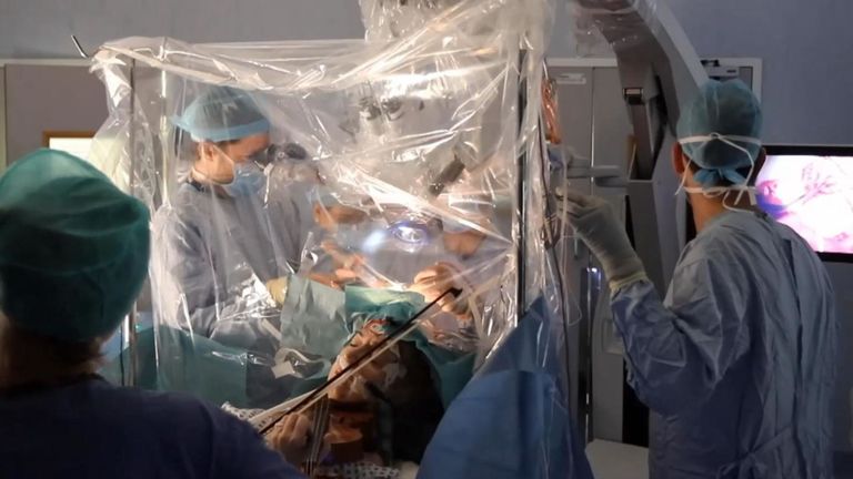 woman plays violin during surgery